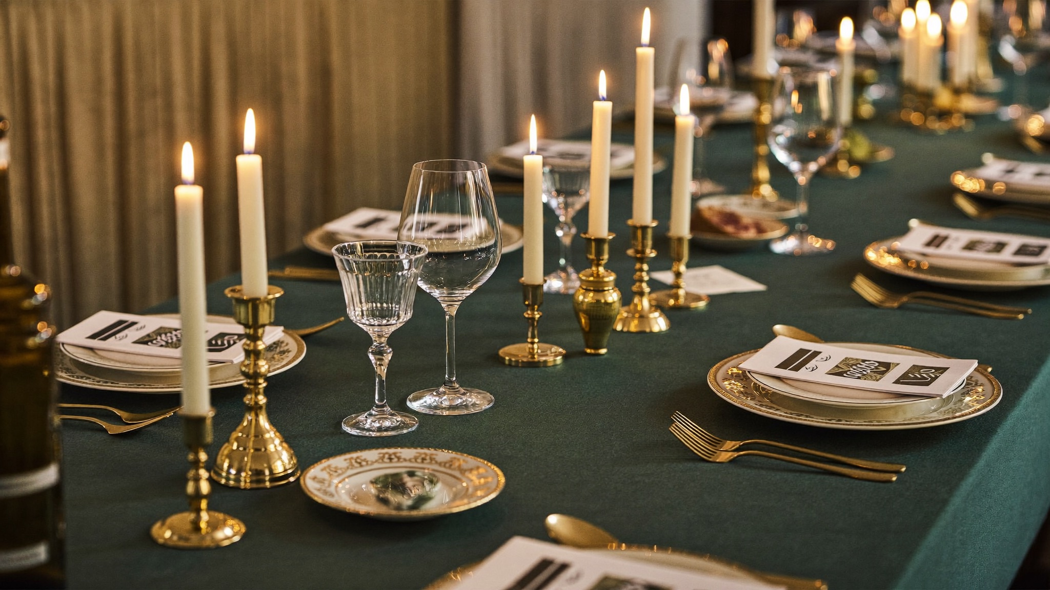 A candlelit table set in green and gold